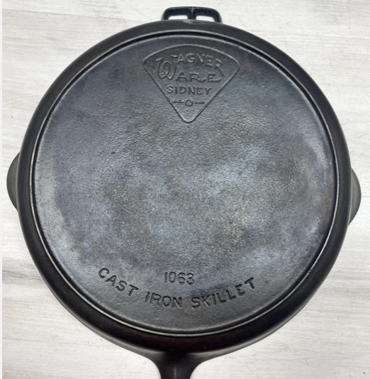 Bottom of Wagner cast iron "Pie Logo" cast iron skillet number 13, catalog number 1063 with heat ring.